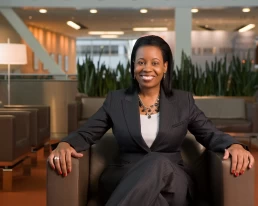 A woman in a business suit sitting in an office for her company headshot.