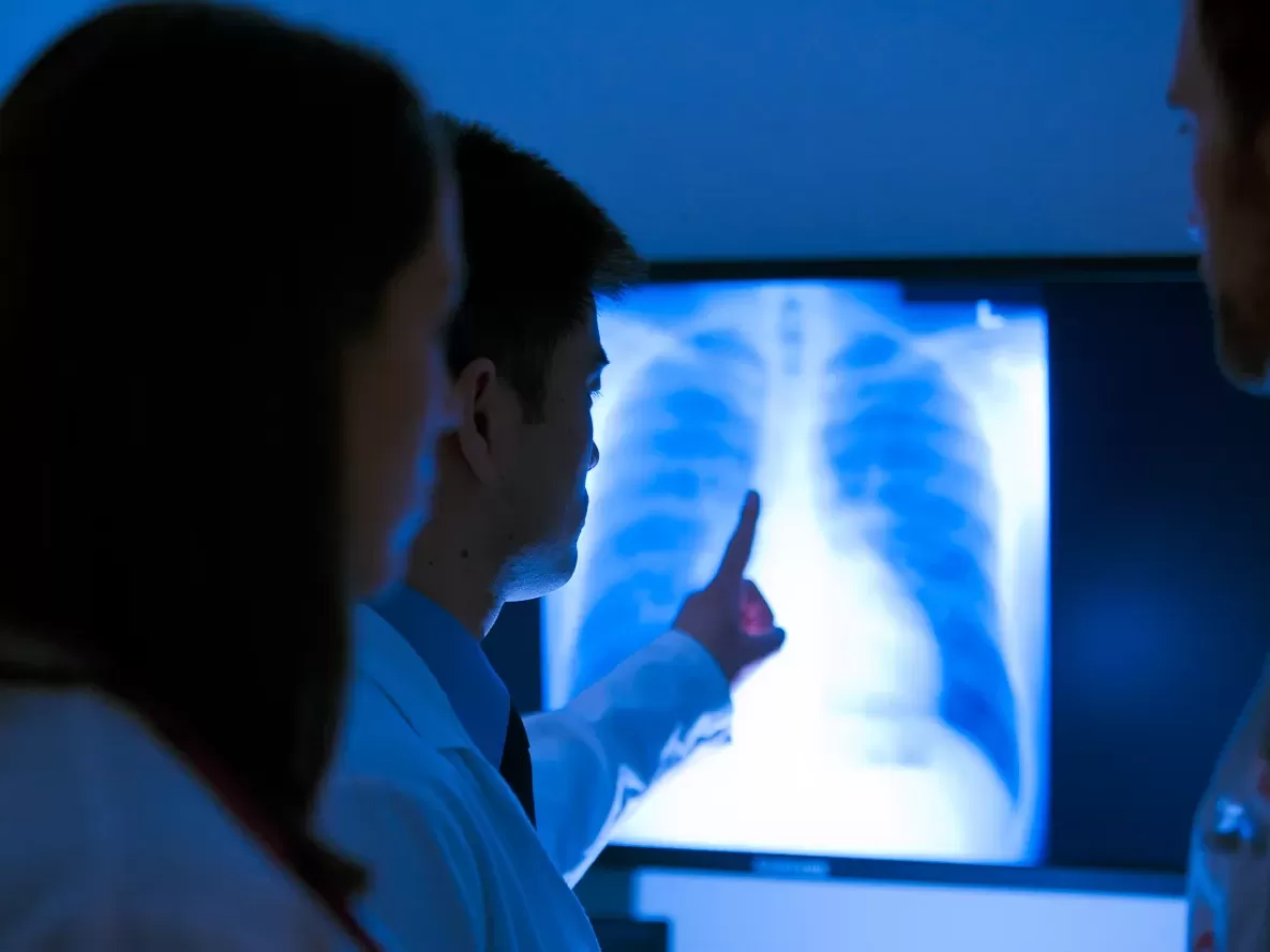 A group of medical professionals examining an x-ray.