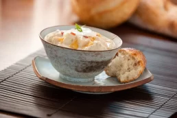 A headshot of a bowl of soup with bread on top.