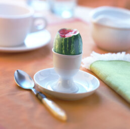 A cup and saucer with tiny watermelon in it. Composite image -photoshopped