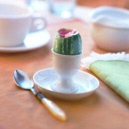 A cup and saucer with tiny watermelon in it. Composite image -photoshopped