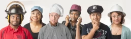 A group of people wearing hats for their company headshot.