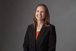 A woman in a black suit smiles for the camera in her professional headshot.
