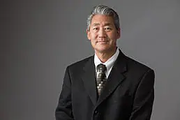A company headshot of a man in a suit and tie is being taken.