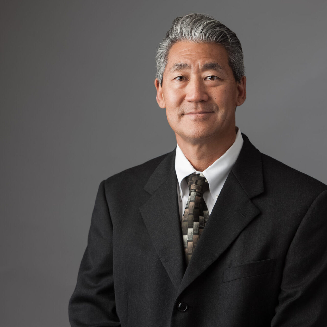 A company headshot of a man in a suit and tie is being taken.