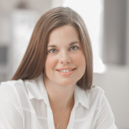 A woman sitting at a desk with a smile on her face for a healthcare photography session.