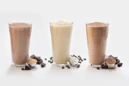 Three Headshot chocolate milkshakes on a white background.