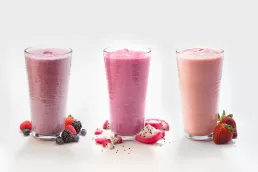 Three different types of smoothies are shown on a white background in this food photography.