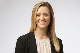 A woman in a business suit smiling for a headshot.