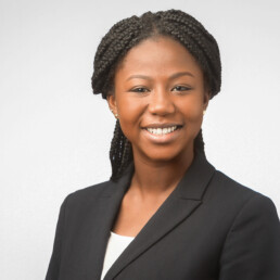 A black woman in a business suit smiling for her company headshot.
