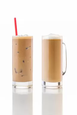 Two iced coffees on a white surface for a food photography session.