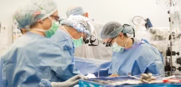 A group of healthcare professionals performing surgery in an operating room.