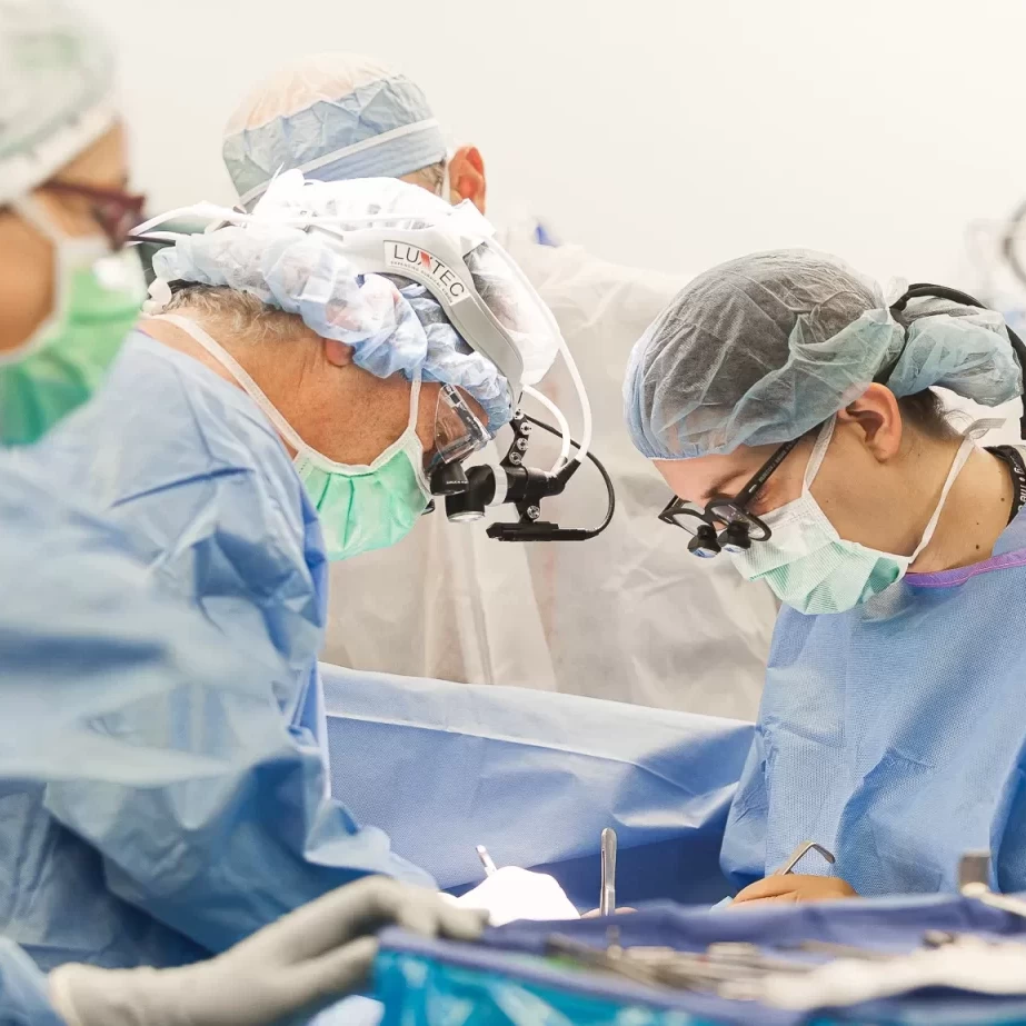 A group of healthcare professionals performing surgery in an operating room.