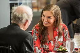 A woman and an older man sitting at a table for healthcare event photography.