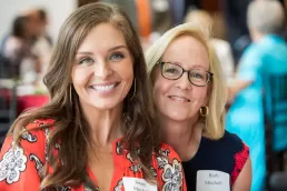 Two women posing for a photo at an event.