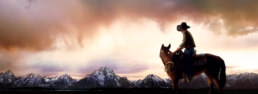 A cowboy on a horse with mountains in the background, creating a conceptual image.