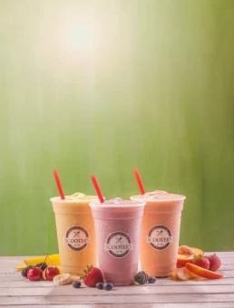 Three fruit smoothies on a wooden table, showcased for a health care photography portfolio.