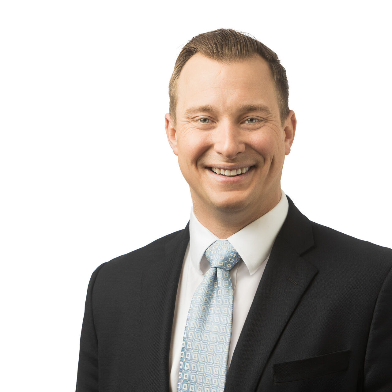 A smiling man in a suit and tie for a company headshot.
