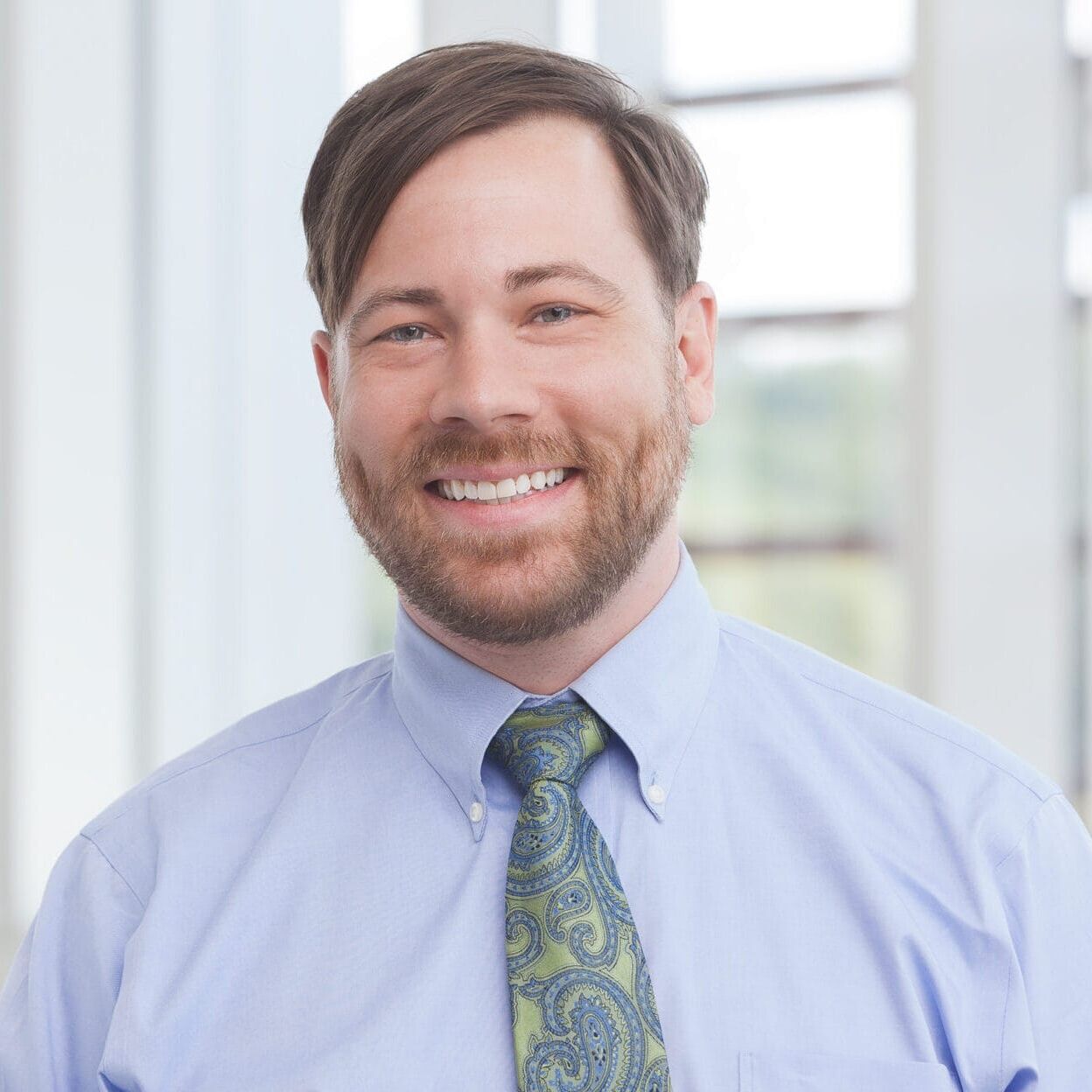 A company Headshot of a man smiling at the camera.