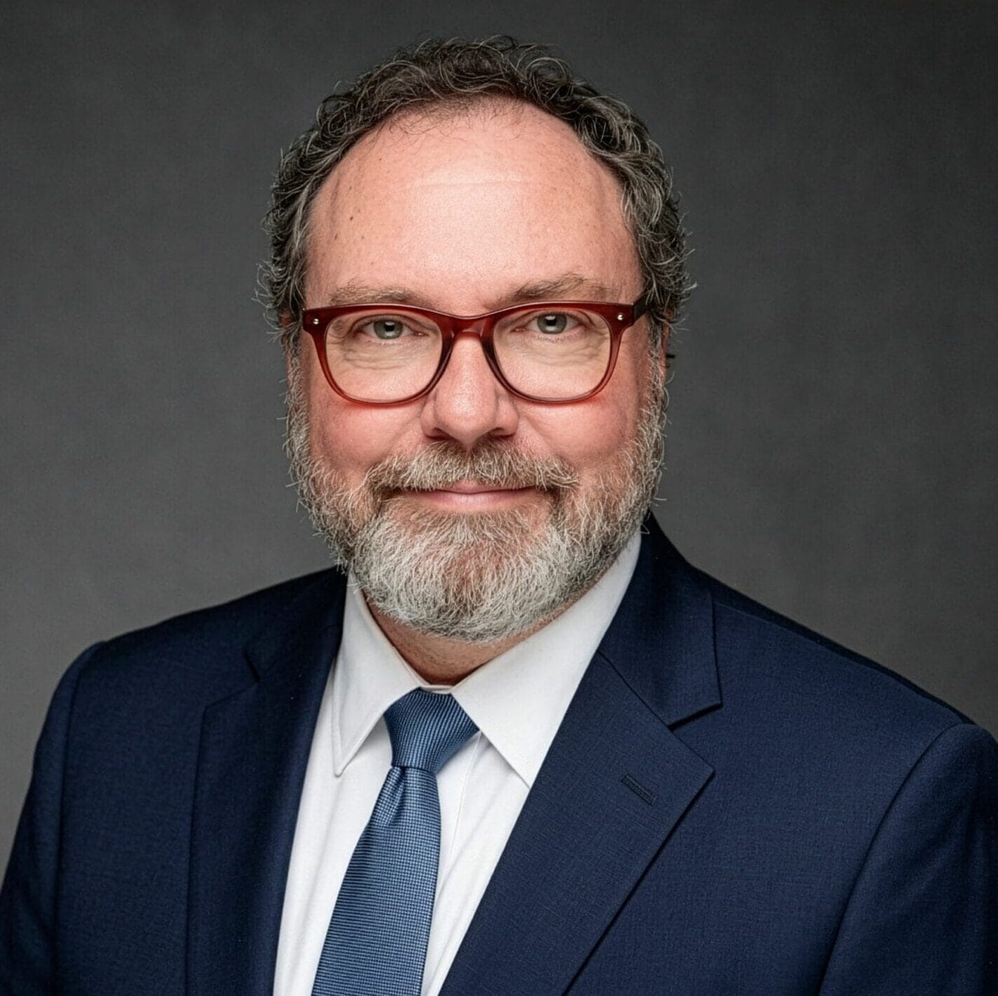 Professional AI headshot of man in suit with glasses and beard.